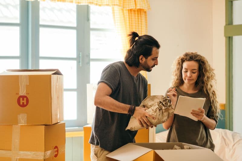 Una pareja desempacando cajas en su casa nueva